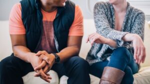 A man and woman sit closely talking